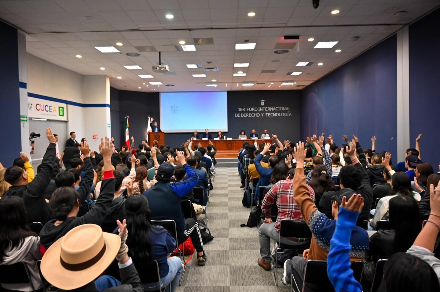 Audiencia con manos alzadas durante dinámica participativa
